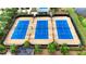 Aerial view of three well-maintained blue tennis courts enclosed by a black fence at 5237 Nw 48Th Pl, Ocala, FL 34482