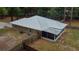 Aerial view of the back of a house with a metal roof, screened in porch, and fenced yard at 3005 Se 156Th Place Rd, Summerfield, FL 34491