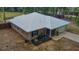 Aerial view of a home with a metal roof, attached garage, and front yard landscaping at 3005 Se 156Th Place Rd, Summerfield, FL 34491