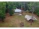 Aerial view of a metal roof home and separate covered structure on wooded lot at 3005 Se 156Th Place Rd, Summerfield, FL 34491