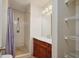 Bathroom featuring an antique vanity, walk-in shower with tiled surround, and wire shelving at 3005 Se 156Th Place Rd, Summerfield, FL 34491