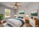 A staged bedroom with hardwood floors, neutral walls, art, lamps and a queen sized bed at 3005 Se 156Th Place Rd, Summerfield, FL 34491