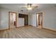 Bedroom featuring neutral walls and wood-look floors leading to a bathroom and kitchen at 3005 Se 156Th Place Rd, Summerfield, FL 34491