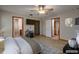 Staged bedroom featuring neutral walls and wood-look floors leading to a bathroom and kitchen at 3005 Se 156Th Place Rd, Summerfield, FL 34491