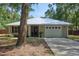 Charming single-story home with a light beige exterior, a white metal roof, and a well-maintained front lawn at 3005 Se 156Th Place Rd, Summerfield, FL 34491