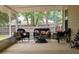 Comfortable screened porch with wicker furniture and outdoor foliage views at 3005 Se 156Th Place Rd, Summerfield, FL 34491