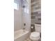 Bathroom featuring a tub with tile surround, rain shower head, and coordinating wood-look wall tiles at 1157 Hollow Pine Dr, Oviedo, FL 32765