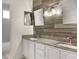 Elegant bathroom with double sinks, granite countertops, and wood-look accent wall, creating a spa-like ambiance at 1157 Hollow Pine Dr, Oviedo, FL 32765