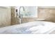 Close-up of a luxurious bathtub with filling water, with elegant tile surround at 1157 Hollow Pine Dr, Oviedo, FL 32765