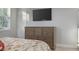 Bedroom featuring a wooden dresser with a mounted TV above, complemented by natural light from the window at 1157 Hollow Pine Dr, Oviedo, FL 32765