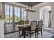 Bright dining room with large windows, stylish curtains, a modern light fixture, and a dark wood dining set at 1157 Hollow Pine Dr, Oviedo, FL 32765