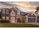 Stunning two-story home with a well-manicured lawn and an elegant entrance, set against a backdrop of a beautiful sunset at 1157 Hollow Pine Dr, Oviedo, FL 32765
