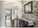 Elegant foyer featuring a decorative stone wall and dark wood floors, leading to a view of the outdoor pool area at 1157 Hollow Pine Dr, Oviedo, FL 32765