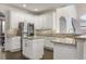 Modern kitchen features white cabinetry, stainless steel appliances, granite countertops, and a center island at 1157 Hollow Pine Dr, Oviedo, FL 32765