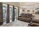 Open-concept living room with sliding glass doors, a comfortable leather couch, and dark wood floors, seamlessly connecting indoor and outdoor spaces at 1157 Hollow Pine Dr, Oviedo, FL 32765