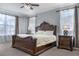 Main bedroom featuring a large decorative bedframe, side tables, and ample natural light at 1157 Hollow Pine Dr, Oviedo, FL 32765