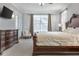 Bright main bedroom with large bed, French doors, TV, and elegant furniture at 1157 Hollow Pine Dr, Oviedo, FL 32765