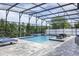 Beautiful screened-in pool with a brick paver deck and waterfall feature at 1157 Hollow Pine Dr, Oviedo, FL 32765