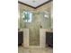 Spacious tile shower with glass enclosure, multiple shower heads, and corner window at 1157 Hollow Pine Dr, Oviedo, FL 32765