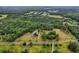 A picturesque aerial view of a charming property with a lush landscape and long private drive at 20250 Nw 71St Ct, Micanopy, FL 32667