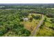 An impressive aerial perspective of a private estate surrounded by lush greenery and towering trees at 20250 Nw 71St Ct, Micanopy, FL 32667