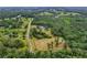 Aerial view of a property on a tree-lined lot near roads and other homes at 20250 Nw 71St Ct, Micanopy, FL 32667