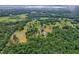 An aerial view of a property and surrounding trees in a verdant neighborhood at 20250 Nw 71St Ct, Micanopy, FL 32667