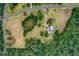 An attractive aerial view showcasing a property with a winding driveway, pond, and wooded surroundings at 20250 Nw 71St Ct, Micanopy, FL 32667