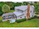 Backyard view showcasing a screened-in porch with a hot tub, lush lawn, and mature landscaping at 20250 Nw 71St Ct, Micanopy, FL 32667