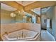 Elegant bathroom featuring a jacuzzi tub with gold fixtures and an ornate chandelier at 20250 Nw 71St Ct, Micanopy, FL 32667