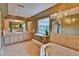 Bright bathroom features double sinks, a soaking tub, chandelier and a scenic window view at 20250 Nw 71St Ct, Micanopy, FL 32667