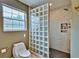 Well-lit bathroom featuring a glass block partition between the toilet and walk-in shower at 20250 Nw 71St Ct, Micanopy, FL 32667