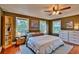Main bedroom with warm wood floors, a fan, ample natural light, and tasteful decor at 20250 Nw 71St Ct, Micanopy, FL 32667