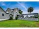 View of the house from the lush green lawn with screened in porch at 20250 Nw 71St Ct, Micanopy, FL 32667
