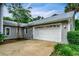 Detached garage featuring a metal roof, white garage door, and well-maintained landscaping at 20250 Nw 71St Ct, Micanopy, FL 32667