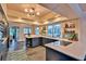 Bright kitchen with slate floors, blue cabinets, a central island with cooktop, and open shelving, under recessed and modern lighting at 20250 Nw 71St Ct, Micanopy, FL 32667