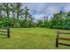 Land with green grass and wooded fencing at 20250 Nw 71St Ct, Micanopy, FL 32667