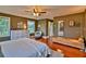 Spacious bedroom with wood floors features an accent chair, dresser and lots of natural light at 20250 Nw 71St Ct, Micanopy, FL 32667