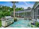 Backyard patio features outdoor grill and seating by the screened-in pool at 20250 Nw 71St Ct, Micanopy, FL 32667