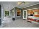 Relaxing screened porch with ceiling fan and tile floor, leads to living area through glass doors at 20250 Nw 71St Ct, Micanopy, FL 32667