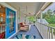Covered porch offers a swing, blue flooring and railing with scenic views at 20250 Nw 71St Ct, Micanopy, FL 32667