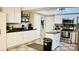 Kitchen with white cabinets, stainless steel appliances, island with black countertop, and tile flooring at 251 Celery Cir, Oviedo, FL 32765