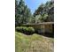 Exterior view of a stone sided home with lush, mature trees, greenery and overgrown lawn at 15750 Ne 150Th Ter, Fort Mc Coy, FL 32134