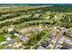 Aerial view of a gray home surrounded by trees and a golf course in the distance at 17781 Sw 72Nd Street Rd, Dunnellon, FL 34432