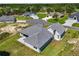 An aerial view shows a grey home surrounded by grass, trees, and other houses in a neighborhood at 17781 Sw 72Nd Street Rd, Dunnellon, FL 34432