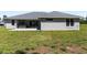 Back exterior shot showing the patio, hot tub, and lush green lawn at 17781 Sw 72Nd Street Rd, Dunnellon, FL 34432