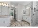 Dual vanity bath with granite counters and tiled floors leading to a shower at 17781 Sw 72Nd Street Rd, Dunnellon, FL 34432
