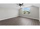 Bright bedroom with wood-look floors, ceiling fan, and large window with a view at 17781 Sw 72Nd Street Rd, Dunnellon, FL 34432