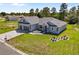 Gray home with a paver driveway, two-car garage, and landscaped front yard at 17781 Sw 72Nd Street Rd, Dunnellon, FL 34432