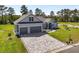 Gray home with a paver driveway, two-car garage, and landscaped front yard at 17781 Sw 72Nd Street Rd, Dunnellon, FL 34432